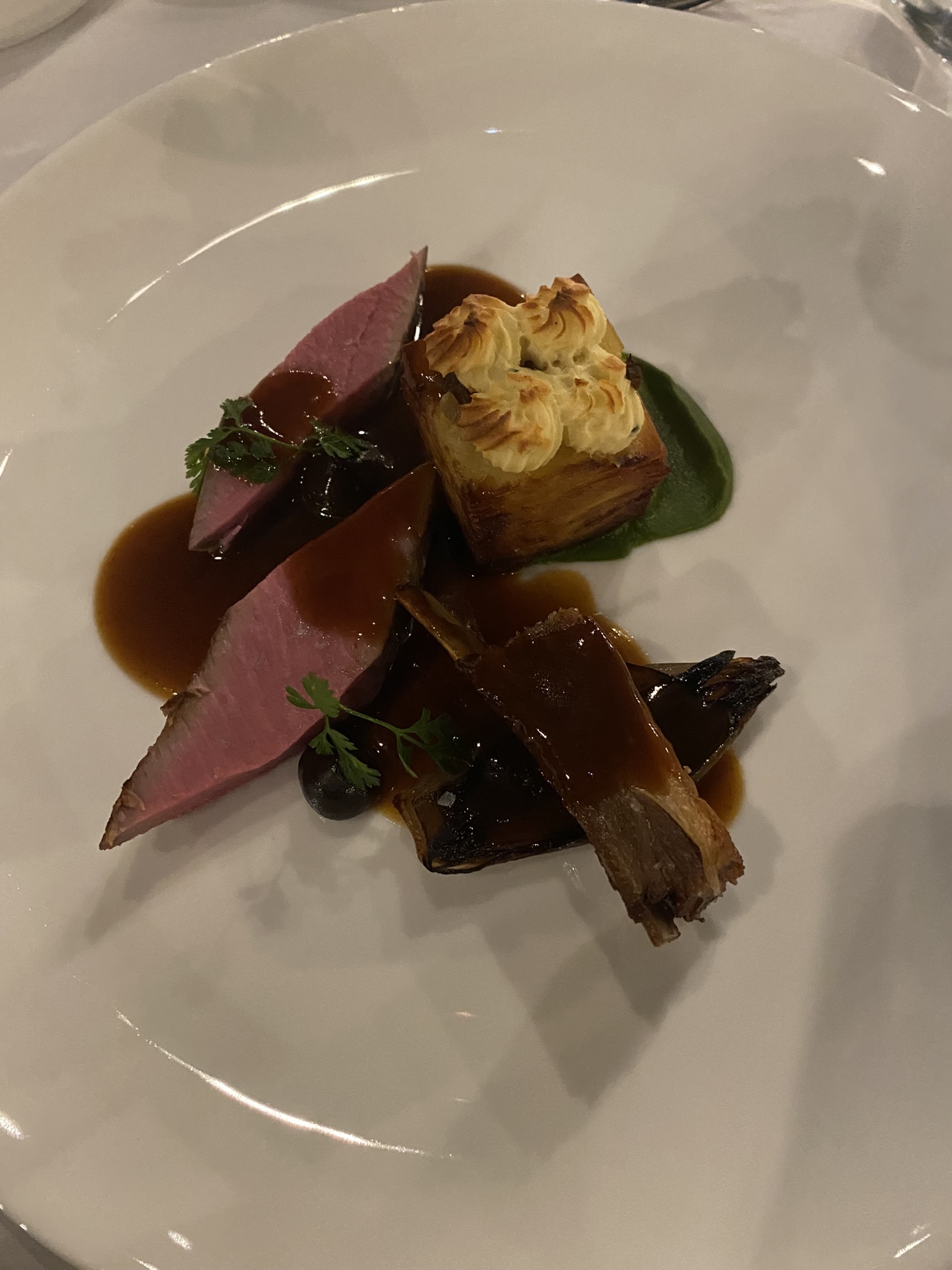 Slices of lamb covered in jus on plate at event in Dubai