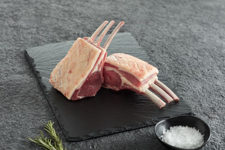 Rack of lamb with sprigs of rosemary and pot of salt
